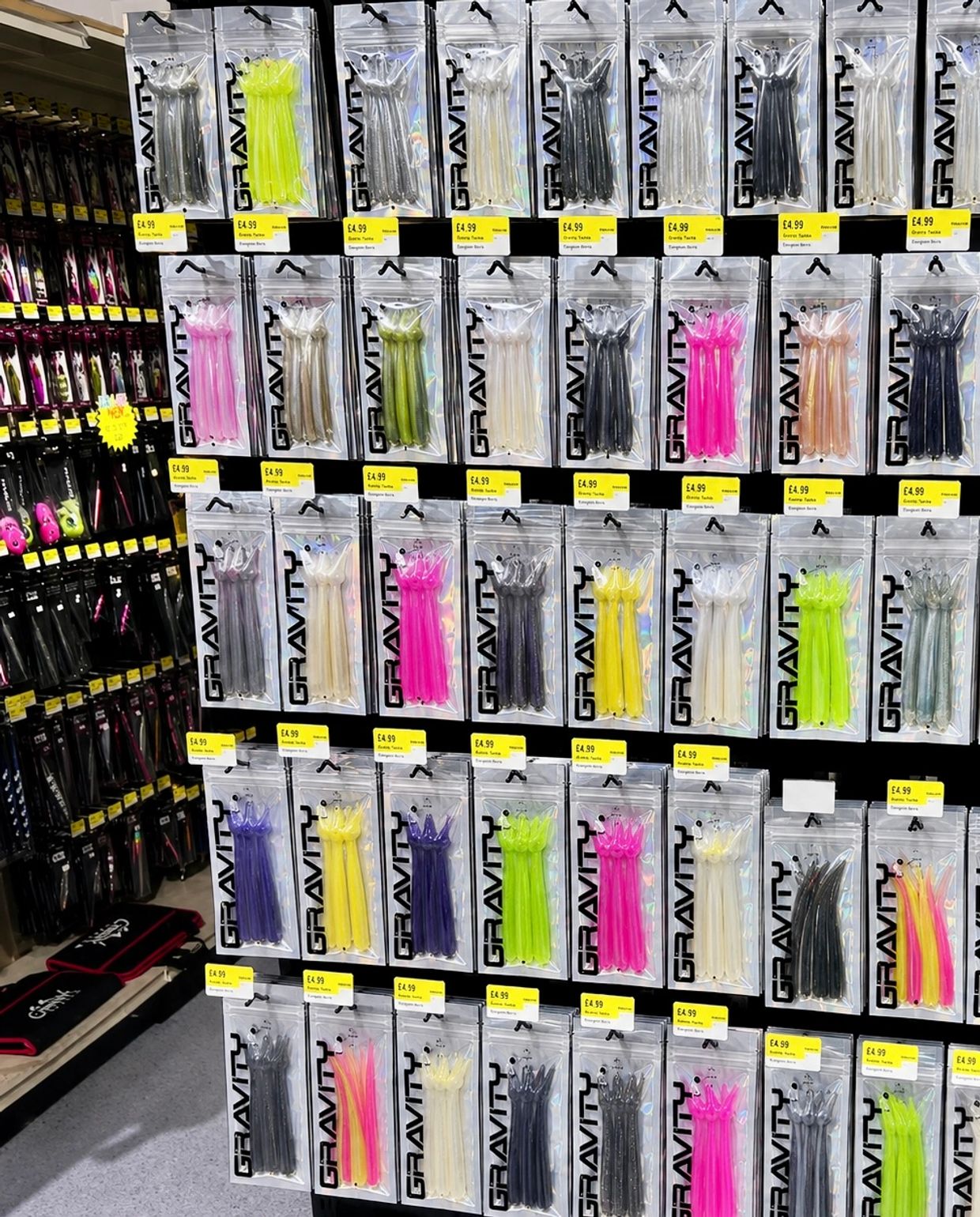 Colorful fishing lures neatly displayed in packages on a store wall.