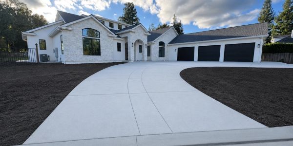 Large modern white house with a clean driveway.
