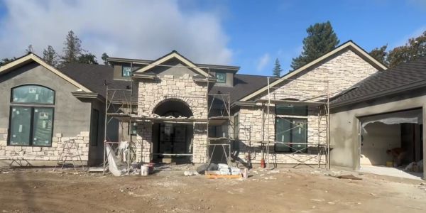 Large house under construction with scaffolding.