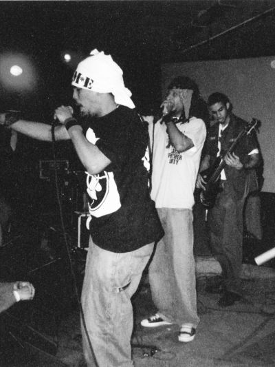 Black and white image of musicians performing onstage.