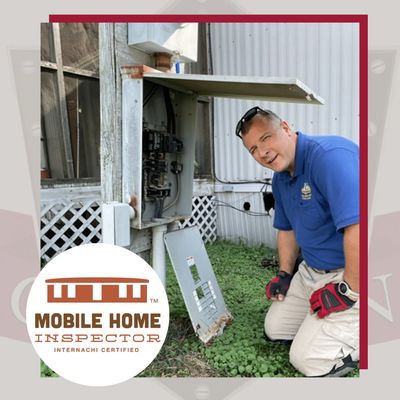Certified mobile home inspector checking electrical panel outdoors.