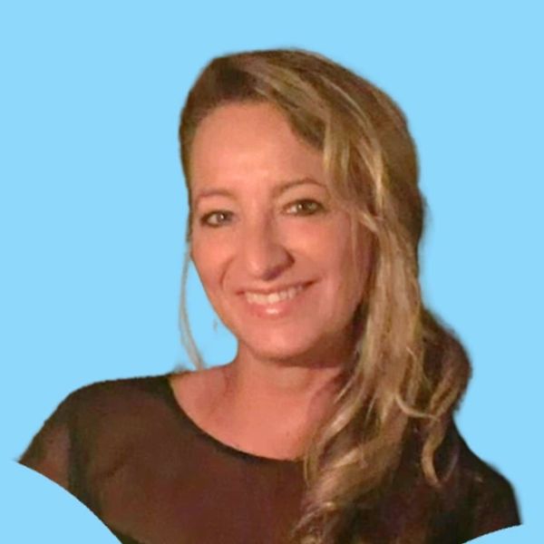 Smiling woman with blonde hair against a blue background.