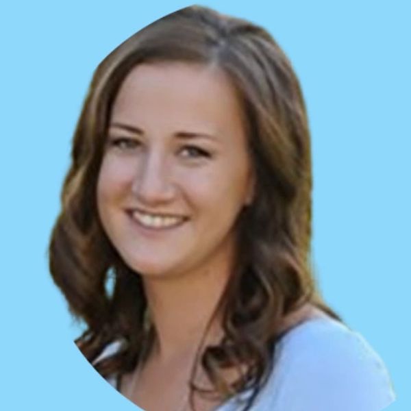 Young woman with brown hair smiling against a blue background.