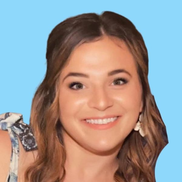 Smiling woman with wavy brown hair and blue background.