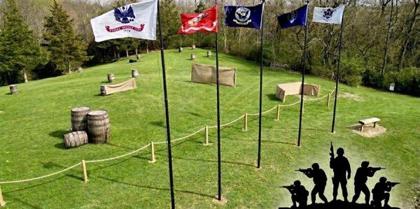 Outdoor military shooting range with flags and targets.