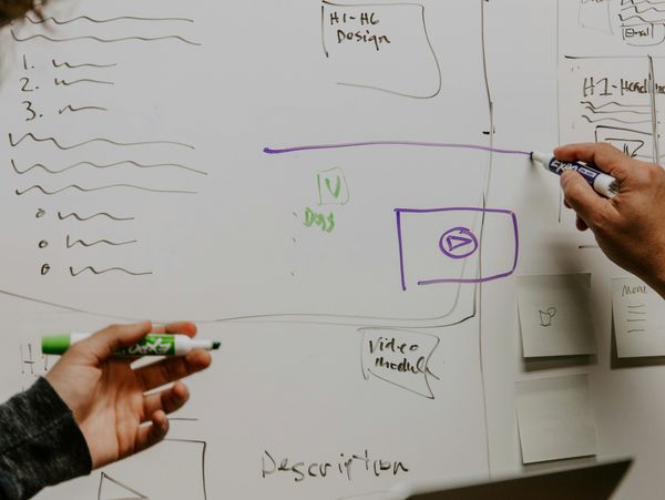 People drawing a technical model on a whiteboard
Photo by Kaleidico on Unsplash