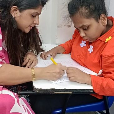 Woman teaching a young girl writing.