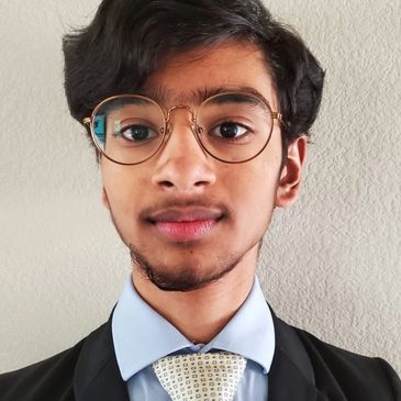 Young man wearing glasses and formal attire.