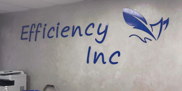 Wall sign displaying 'Efficiency Inc' with a blue feather logo.