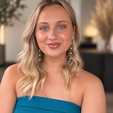Portrait of a smiling woman with blonde hair in a blue top.