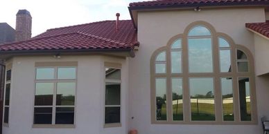 HOUSE WITH RED ROOF AND REFLECTIVE WINDOWS