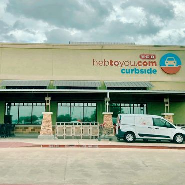 Grocery store picture from the outside and a van parked in front