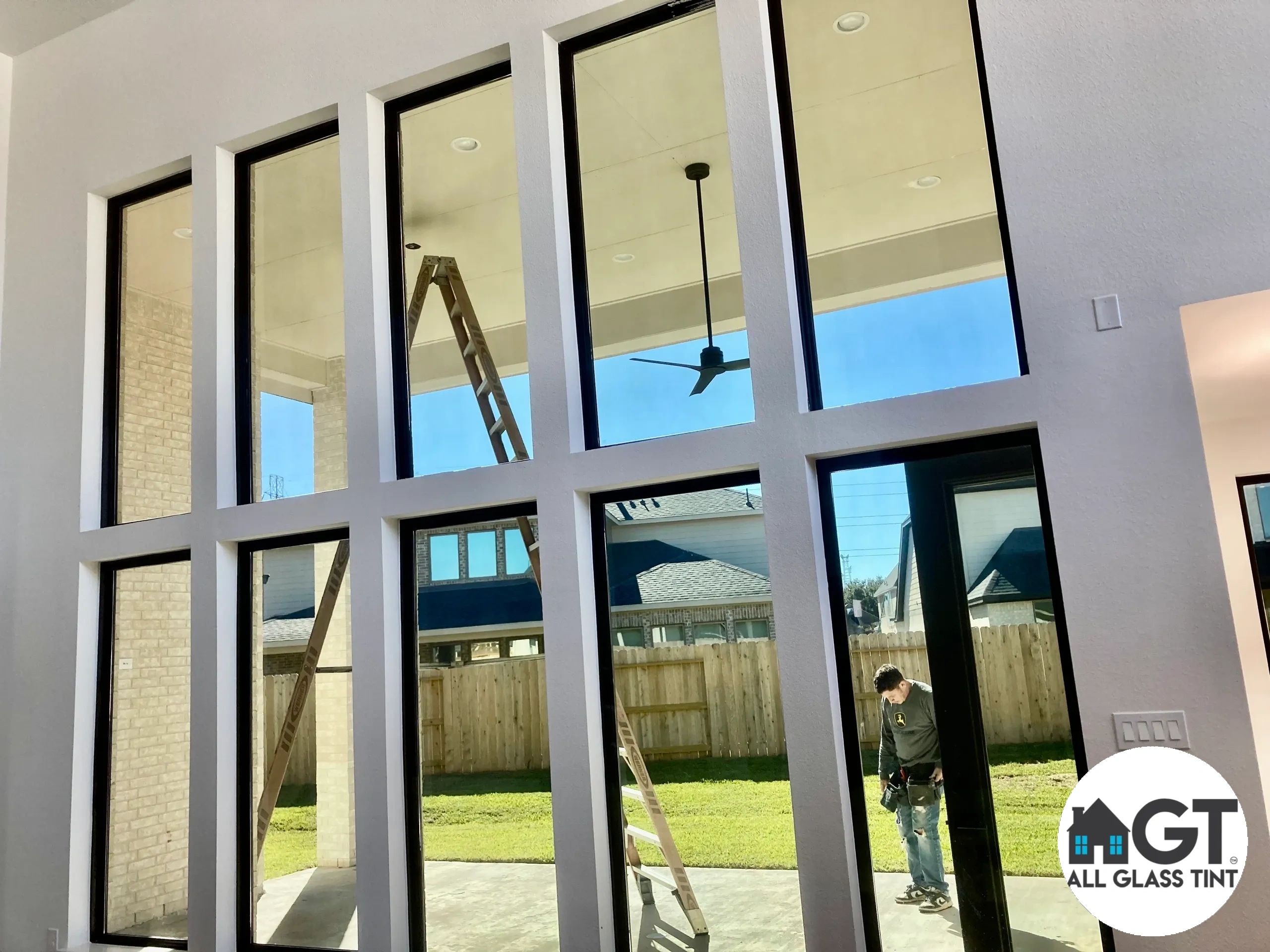  Floor to ceiling windows and man standing next to ladder
