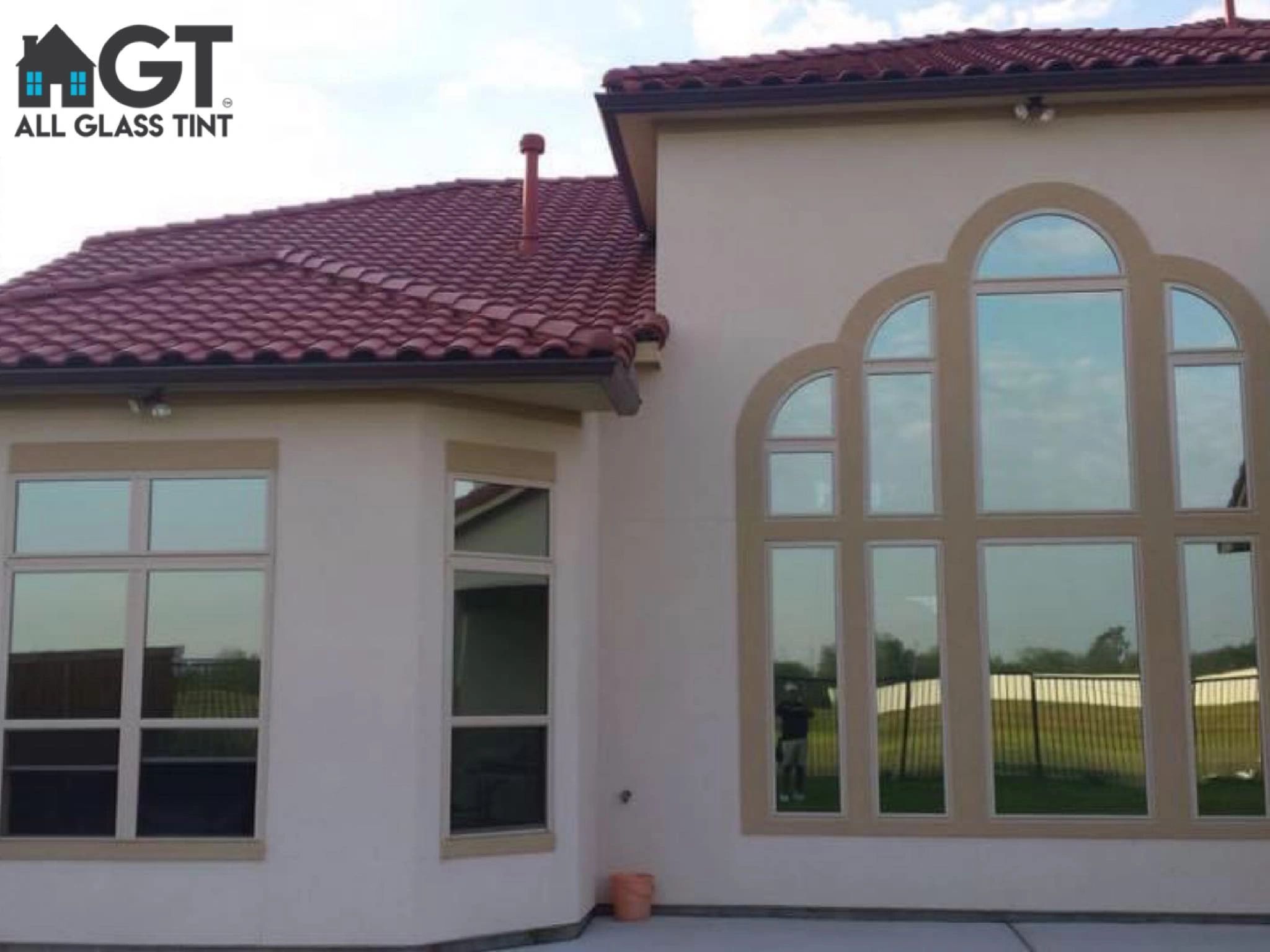 two story home with red roof and reflective windows