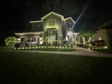 House decorated with white lights at night.