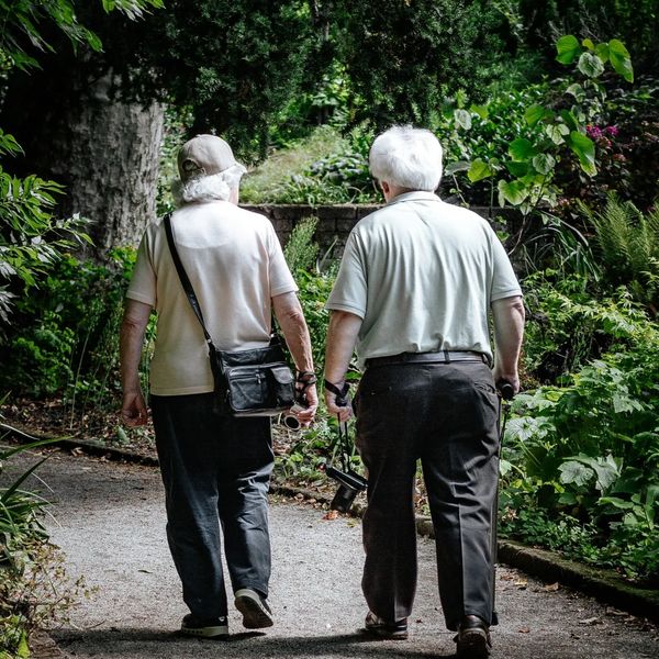 A senior couple walking towards their newly moved house.