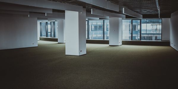 A a spacious, empty commercial office, cleared out in preparation for a move by River City Moving.