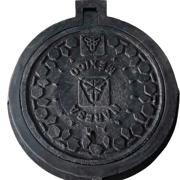 Round black manhole cover with hexagonal patterns and Mexican text.