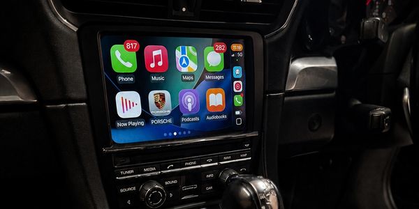 Car infotainment system showing apps like Phone, Music, and Maps.