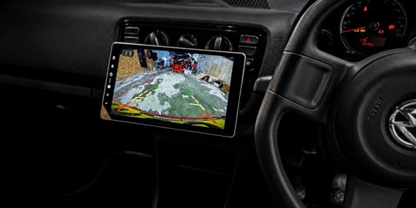 Car dashboard with a backup camera display showing a rear view.