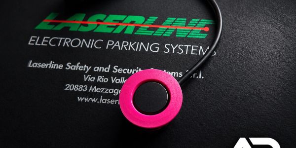 Close-up of a pink circular electronic device on Laserline packaging.