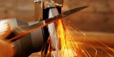A blade being sharpened with sparks flying.
