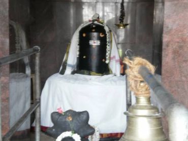 A black Shiva Lingam inside a temple.