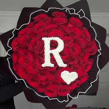 Bouquet of red roses with white letter R and heart.