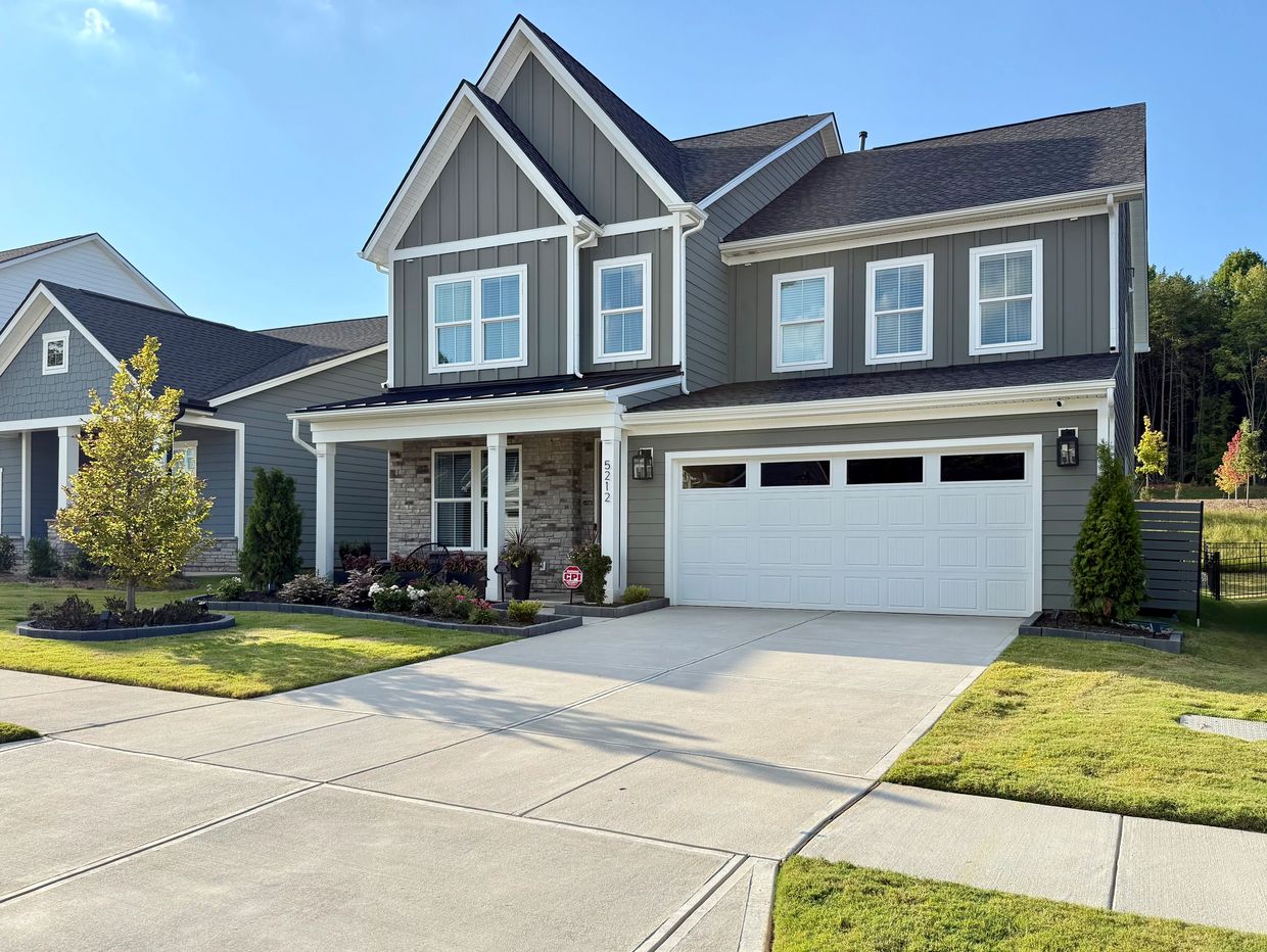 Modern two-story house with a double garage and well-kept lawn.