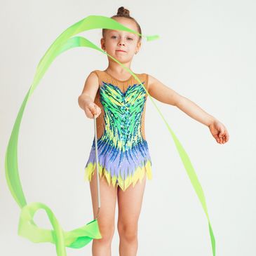 little rhythmic gymnast with a ribbon in a leotard and halfshoes