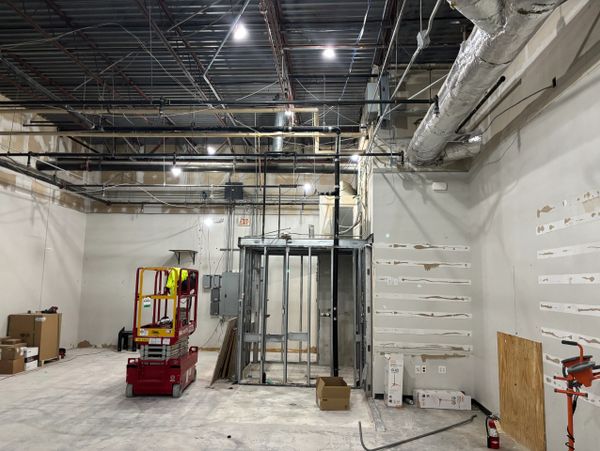 Interior of a commercial space under construction with exposed ceiling and metal framing.