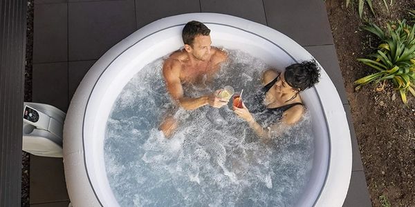 two people enjoying drinks in a hot tub