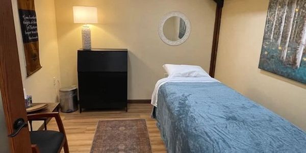 Cozy therapy room with a massage table and soft lighting.
