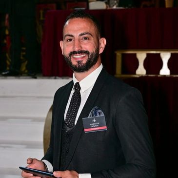 Man in formal attire smiling.