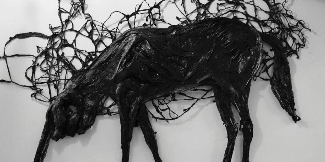 Abstract black sculpture of a horse with tangled lines in the background.
