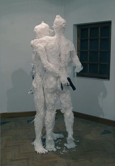 Two human sculptures of white plastic bags embracing, one concealing a gun behind the other's back.