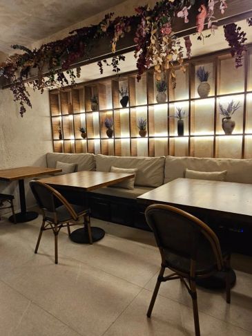 Sala de café con decoración floral y luz cálida.