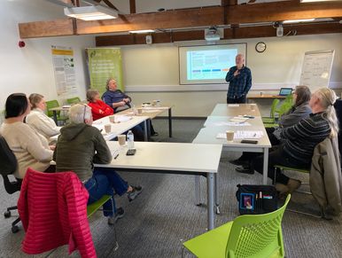 A group attending a presentation in a small conference room.