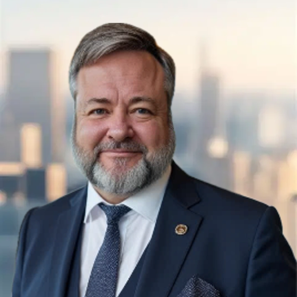 Smiling man in a suit with a cityscape background.