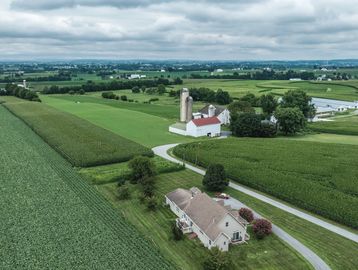 A rural farm with fields and buildings.