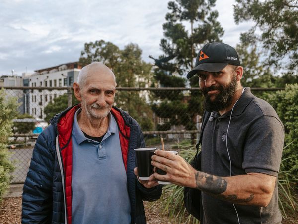 Two men share a cup of coffee from Coffee Brigade