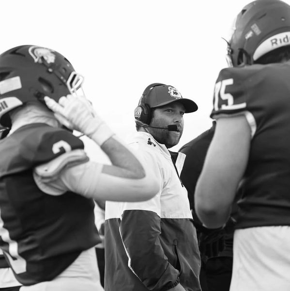 Football coach communicates with players during a game.