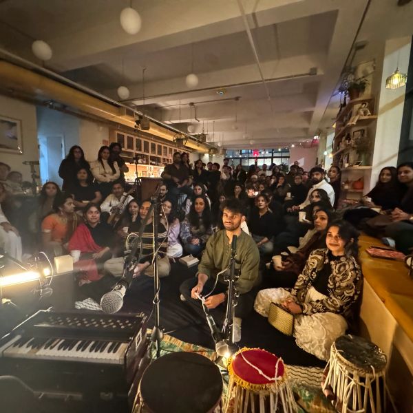 A cozy indoor musical gathering with attentive audience and traditional instruments.