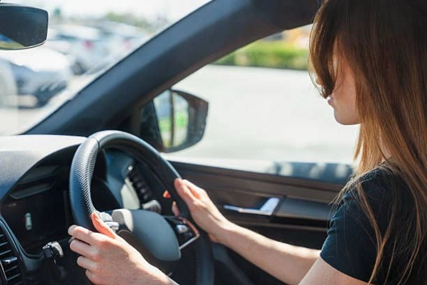 Woman focused on driving a car during the day.