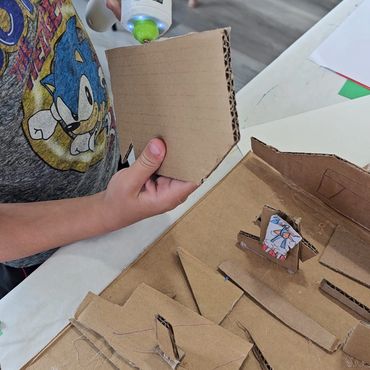 Child gluing cardboard pieces for a project.