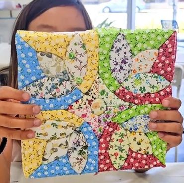 Colorful quilt held by a person.