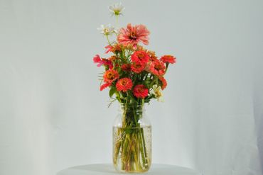 A vibrant bouquet of pink and white flowers in a glass jar.