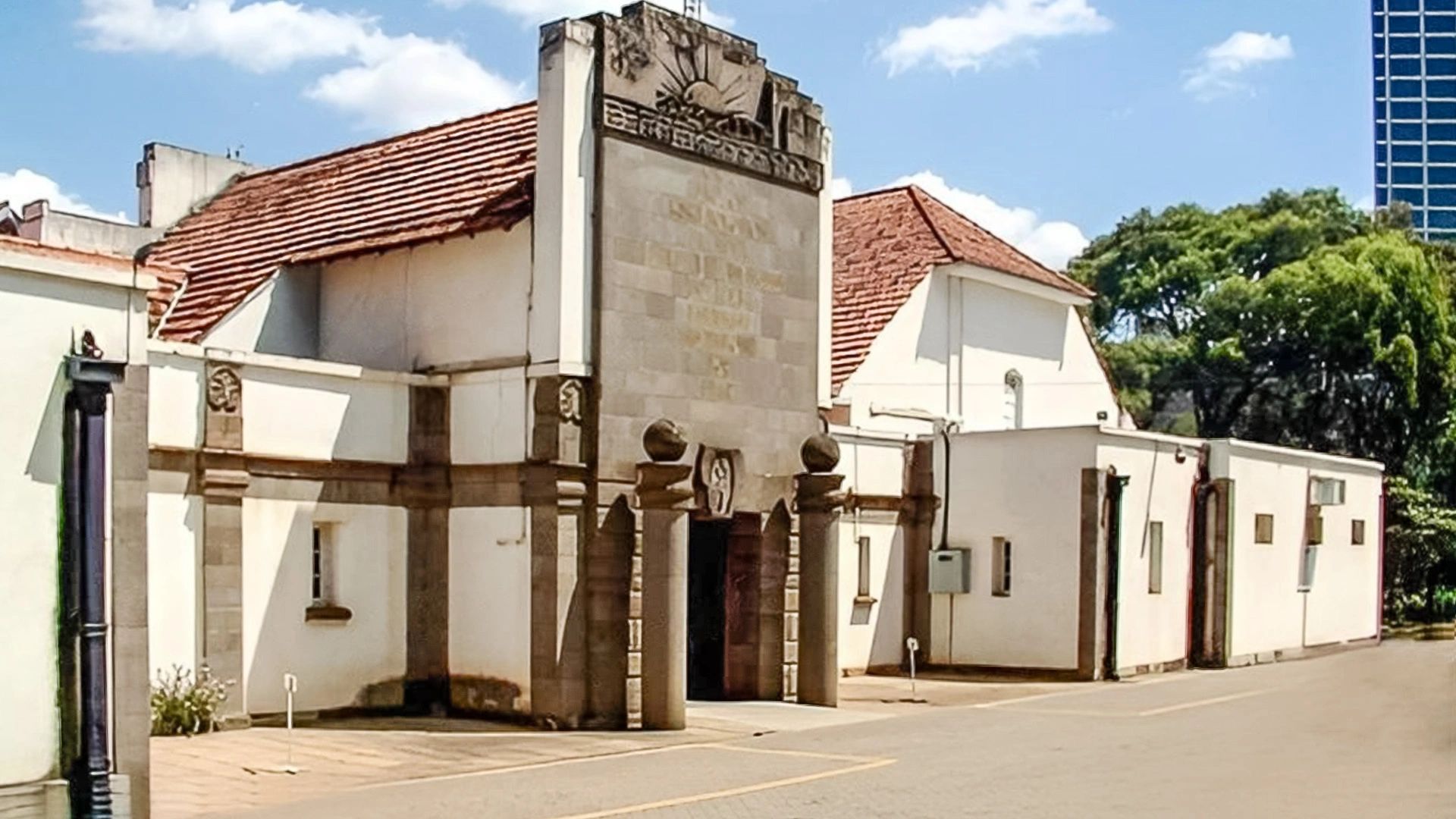 Historic building with stone pillars and a tiled roof under a clear sky.