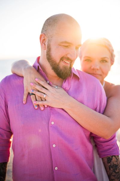 Couple embracing happily with sunlight behind them.