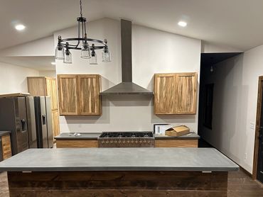 Modern kitchen with wooden cabinets, a large island, and stainless steel appliances.